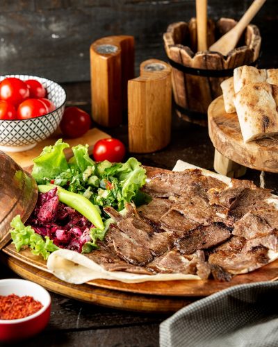 lamb doner slices served with vegetable salad and flatbread