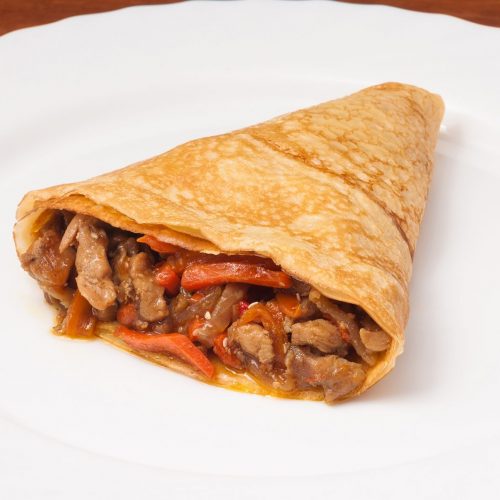 crepes with chicken and vegetables on a white plate